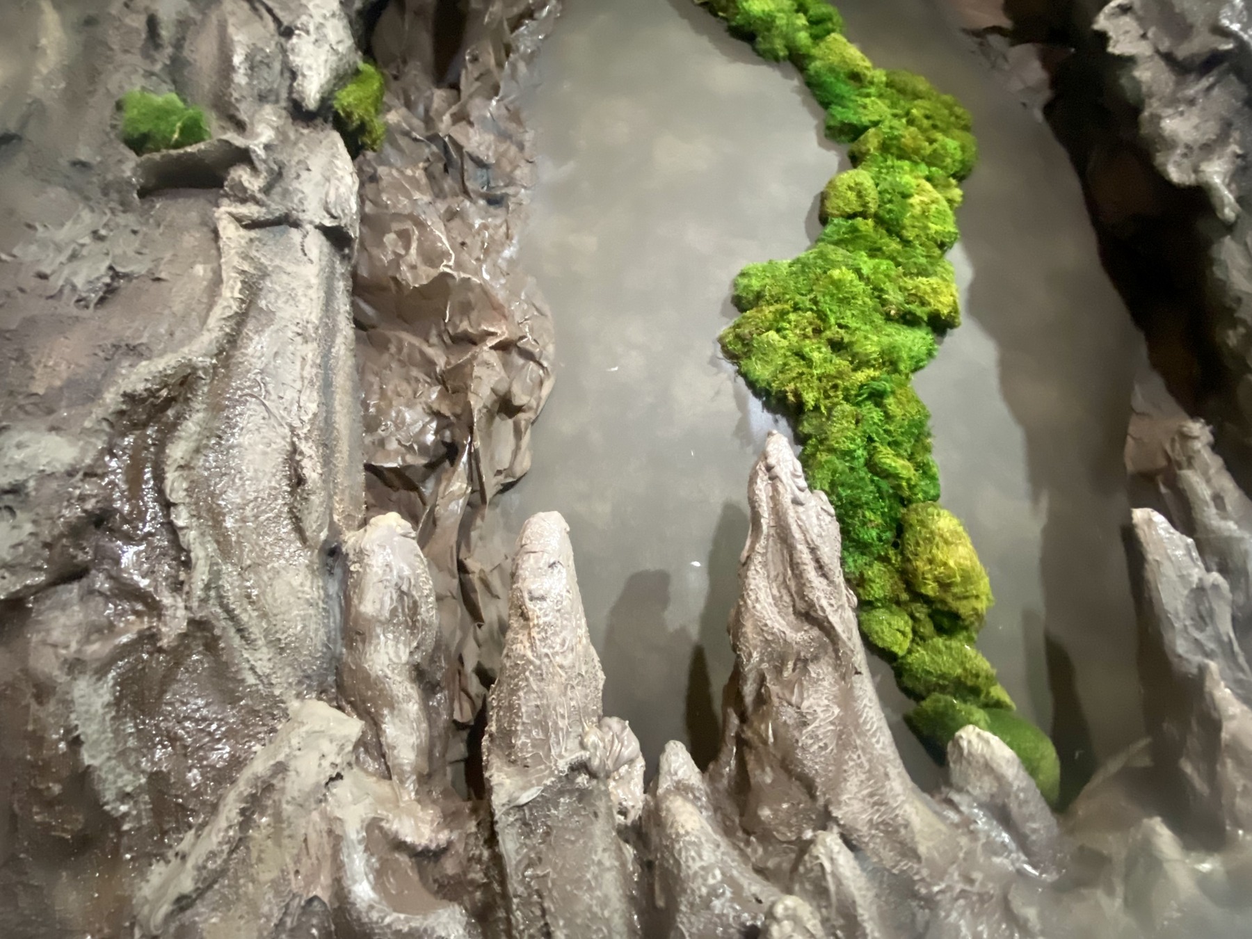 A close view of the sculpted rock texture and moss.